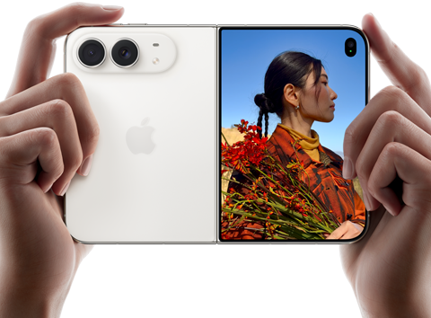 iPhone&nbsp;Duo, Star White colour, held by two hands in horizontal orientation, unfolded, left panel shows 48MP Dual Fusion rear cameras, right panel shows person getting their picture taken on outer display, the subject of the photo is able to see their face as their picture is getting taken using Duo Preview