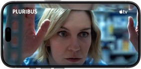 iPhone 18 Pro, landscape mode, displaying a close-up of a woman looking through a shelf. Series title: Pluribus