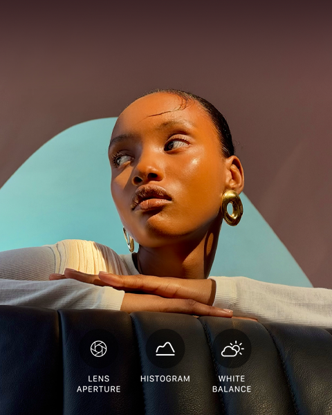 Close-up portrait of a well-lit model with a colourful background, demonstrating the pro camera system’s Pro controls UI: Lens Aperture, Histogram, White Balance